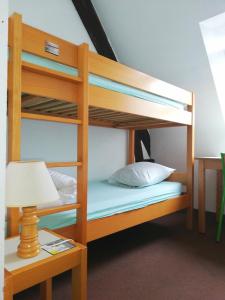 a bunk bed with a lamp and a table at Auberge de Jeunesse HI Pontivy in Pontivy