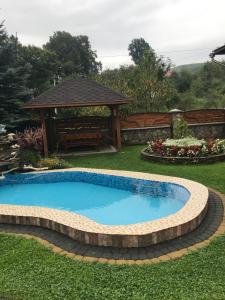 a swimming pool in a yard with a gazebo at Vacation home in Yabluniv