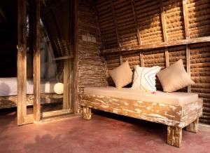 Cette chambre comprend un lit avec des oreillers et un miroir. dans l'établissement Villa Palma Gili Meno - Private Pool, à Gili Meno