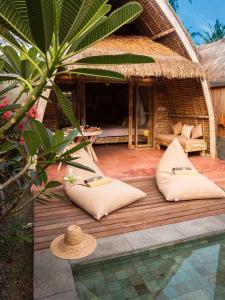 a hut with pillows on a wooden deck next to a pool at Villa Palma Gili Meno - Private Pool in Gili Meno