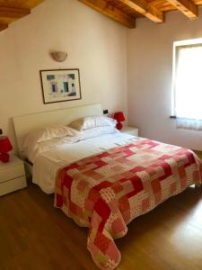 a bedroom with a bed with a quilt on it at Cà Del Polsèt in Brenzone sul Garda