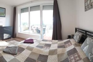 1 dormitorio con cama y ventana grande en Tölgyerdő Apartman en Kismaros