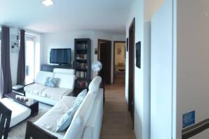 sala de estar con 2 sofás blancos en Tölgyerdő Apartman en Kismaros