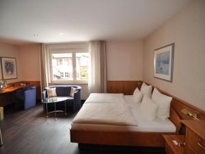 a hotel room with a bed and a desk at Landhotel Pfrondorfer Mühle in Nagold