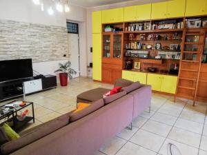 ein Wohnzimmer mit einem Sofa und einem TV in der Unterkunft Oasi di Frattamaggiore in Frattamaggiore