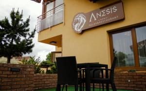 two chairs and a table in front of a building at Penzion Anesis - Apartmány in Turčianske Teplice