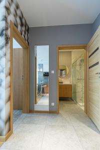 a bathroom with a walk in shower and a glass door at RentApart by Cotton House in Łódź