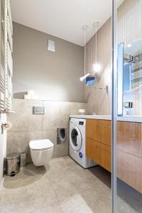 łazienka z toaletą i pralką w obiekcie RentApart by Cotton House w Łodzi