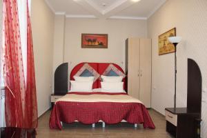 a bedroom with a bed with a red head board at Hotel Atlantida in Kislovodsk