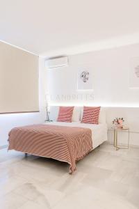 a white bedroom with a bed with red pillows at Apartamento Marina Loft in Benalmádena