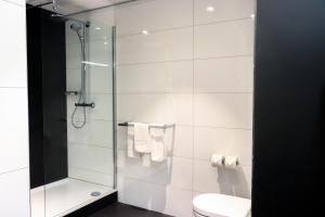 a white toilet sitting next to a shower in a bathroom at Mercure Hotel Tilburg Centrum in Tilburg