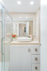 a white bathroom with a sink and a shower at Apartamento Marina Suite in Benalmádena