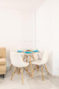 uma sala de jantar branca com uma mesa e cadeiras brancas em Apartamento Marina Suite em Benalmádena