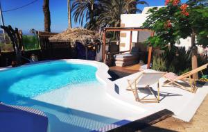 a swimming pool with a chair and a table and a chair at Finca Lucía - Los Hervideros in Mácher +17 photos