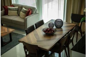 a living room with a wooden table with a bowl of fruit at Pacifica by Damac in Dubai