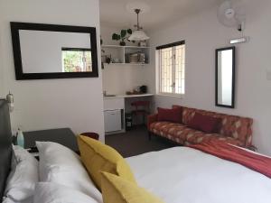 a living room with a bed and a couch at 6 on Kloof Guest House in Bredasdorp