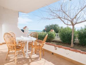 a patio with a table and chairs and a view of the ocean at Casas Pareadas Romana in Alcossebre