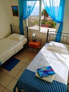 zwei Betten in einem Zimmer mit Meerblick in der Unterkunft Sea front Villa Kristina in Klorakas + 18 Fotos