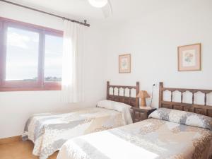 a bedroom with two beds and a window at Casas Pareadas Romana in Alcossebre
