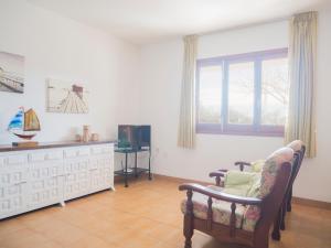 uma sala de estar com uma cadeira, um sofá e uma televisão em Casas Pareadas Romana em Alcossebre