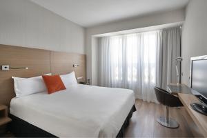 een hotelkamer met een groot bed en een televisie bij Vincci Zaragoza Zentro in Zaragoza