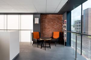 a room with a table and chairs in it at easyHotel Glasgow City in Glasgow