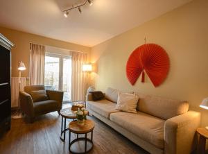 ein Wohnzimmer mit einem Sofa und einem roten Regenschirm an der Wand in der Unterkunft ABACCO Ferienwohnungen in Überlingen