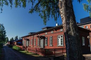 an old wooden building with a tree in front of it at Hostelli Marja in Mikkeli