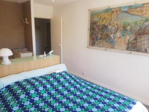 un letto in una stanza con un dipinto sul muro di PALAIS LUMIERE : la ''Chambre Blanche'' a La Ciotat