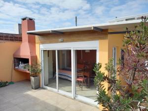 a house with a sliding glass door with a patio at Monoambiente en Colonia in Colonia del Sacramento