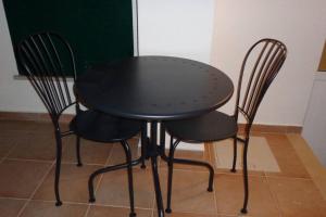 ein schwarzer Tisch und zwei Stühle in einem Zimmer in der Unterkunft Nunes Apartments in Mexilhoeira da Carregacao