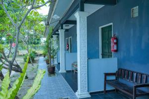 un edificio blu con una panchina davanti di Mila Motel 2 a Pantai Cenang