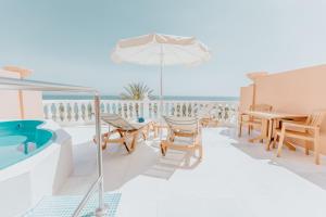 a balcony with a table and chairs and a pool at Hotel Cleopatra Palace in Playa de las Americas