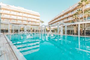 a large swimming pool in front of a building at Hotel Cleopatra Palace in Playa de las Americas