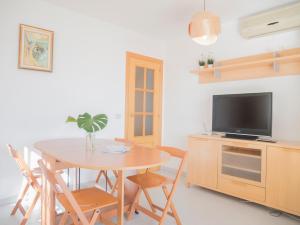 jadalnia ze stołem i telewizorem w obiekcie Apartamentos Irta Playa w mieście Alcossebre
