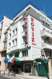 a white building with a hotel sign on it at Noviz Hotel in Plovdiv