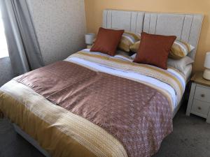 uma cama com duas almofadas num quarto em Harbour Lodge B&B em Paignton