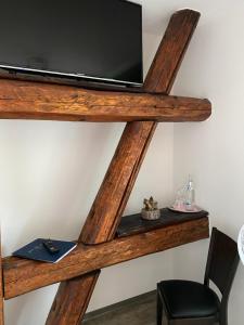 a wooden shelf with a television on a wall at Restaurant & Pension Stadtscheune in Köthen