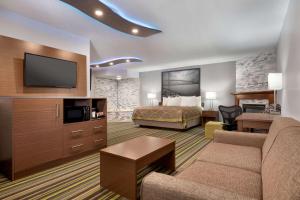 um quarto de hotel com um sofá e uma cama em Super 8 by Wyndham Windsor/Dougall em Windsor