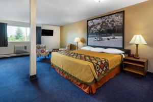 a hotel room with a bed and a large painting on the wall at Sutton Suites Hotel in SeaTac