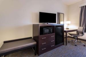 a hotel room with a television and a desk with a chair at Wingate by Wyndham Gurnee in Gurnee