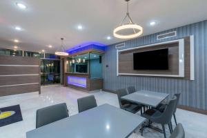 a dining room with two tables and a flat screen tv at Days Inn & Suites by Wyndham Downtown/University of Houston in Houston