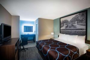A bed or beds in a room at Super 8 by Wyndham Mobile I-65