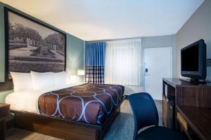 a hotel room with a bed and a television at Super 8 by Wyndham Mobile I-65 in Mobile