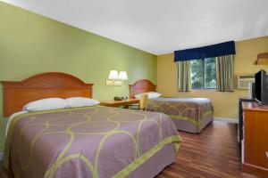 a hotel room with two beds and a television at Super 8 by Wyndham Gainesville in Gainesville