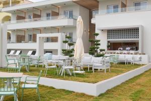 un groupe de tables et de chaises devant un bâtiment dans l'établissement Motivo Thassos, à Skala Potamias