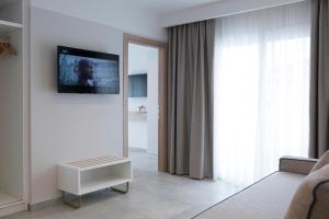 a living room with a mirror and a television on a wall at Motivo Thassos in Skala Potamias