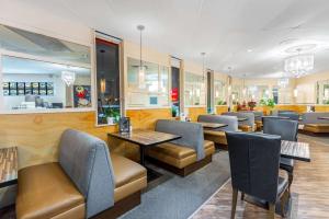 a restaurant with tables and chairs in a room at Ramada by Wyndham Coquitlam in Coquitlam