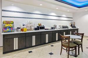 a restaurant with a counter with a table and chairs at La Quinta by Wyndham Fairfield TX in Fairfield