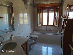 a bathroom with a tub and a toilet and a sink at Casa vacanze a Serra Scirocco in Trabia